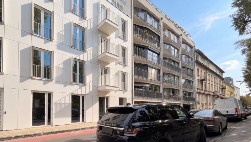 Banskobystrická Straße, Bratislava - Staré Mesto, zeigt moderne Fassaden von Gebäuden und geparkte Autos.