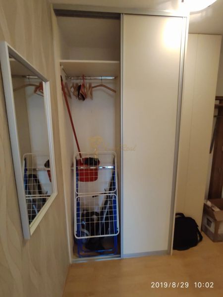 Einbauschrank mit Schiebetüren, Kleiderstangen und Spiegel in einer 2-Zimmer-Wohnung.