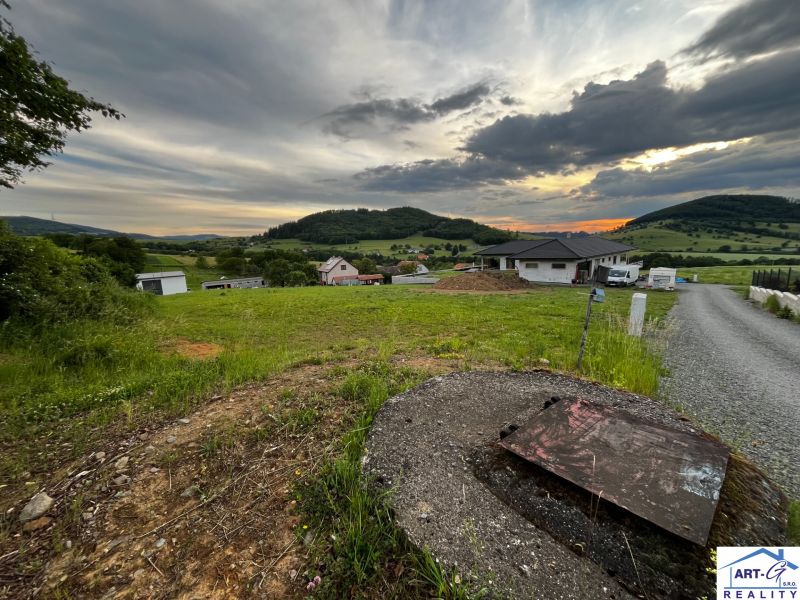 Grundstücke - Wohnen in Stožok mit einer Kulisse aus Grünflächen und Landhäusern bei Sonnenuntergang.