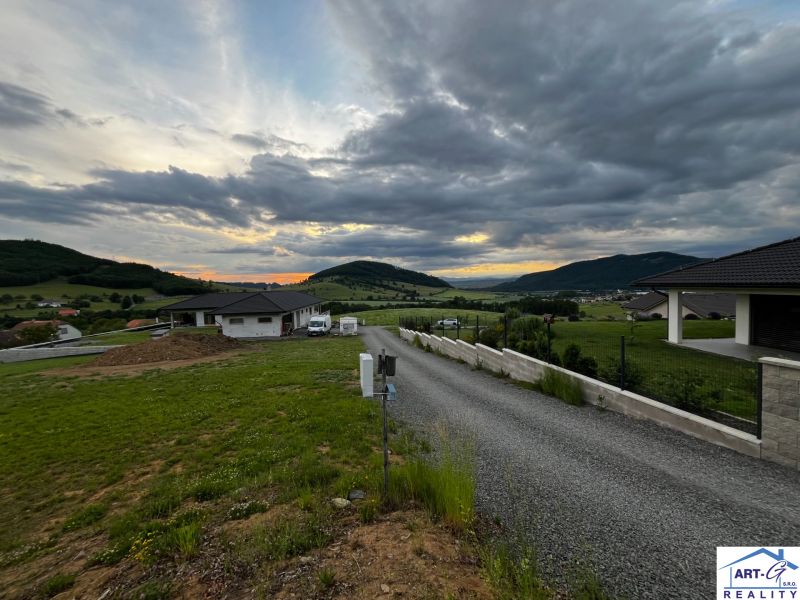 Panorama des Dorfes Stožok mit Sonnenuntergang und Wohnbaugrundstücken in hügeliger Landschaft.