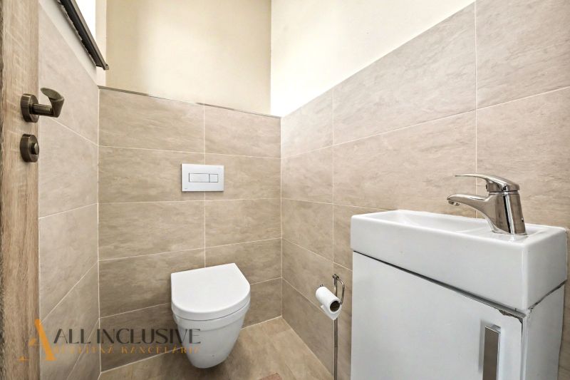 Toilette mit Waschbecken und Fliesen im Einfamilienhaus.