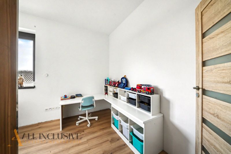 Kinderzimmer in einem Einfamilienhaus mit Holzboden und Aufbewahrungsregalen.