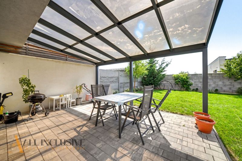Überdachte Terrasse mit Sitzbereich und Grill neben einem Einfamilienhaus in Hrubá Borša.