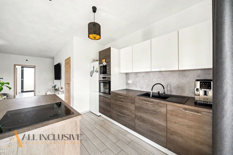 Küche in einem Einfamilienhaus mit Holzboden und modernen Geräten.