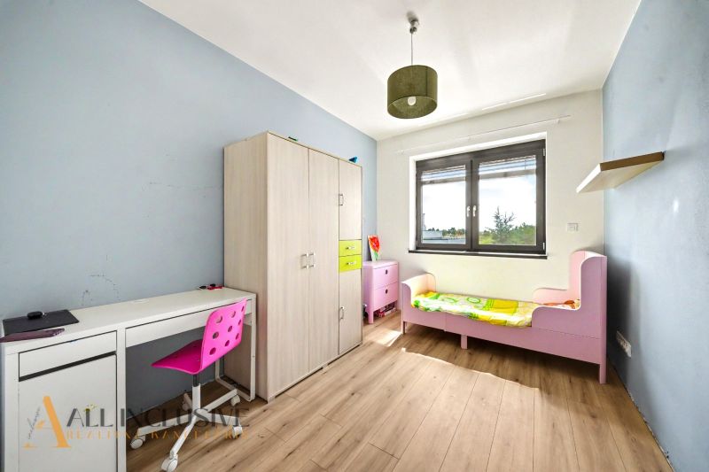 Kinderzimmer mit Bett, Schrank, Schreibtisch und Boden mit Holzdekor.