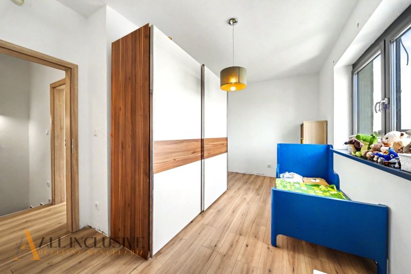 Kinderzimmer mit blauem Bett und Holzboden in einem Einfamilienhaus.