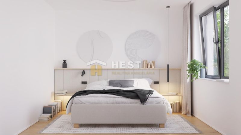 Ein Schlafzimmer in einem Einfamilienhaus mit einem Bett, einer Pflanze und einem Boden mit Holzdekor.
