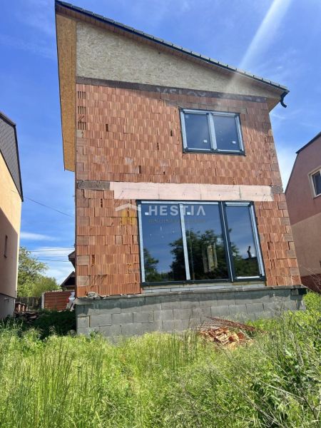 Ein Einfamilienhaus in Cerová im Bauzustand mit unverputzter Ziegelfassade.