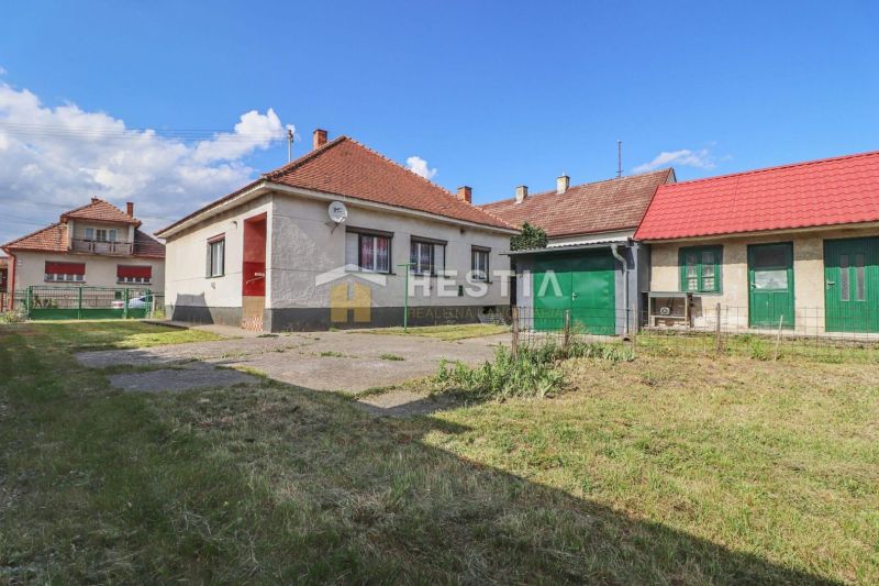 Ein Einfamilienhaus in Borský Mikuláš mit Garten und Garage auf einem Rasenstück.
