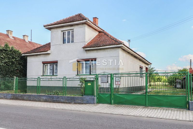 Ein Einfamilienhaus in Borský Mikuláš mit weißen Wänden und einem grünen Zaun.