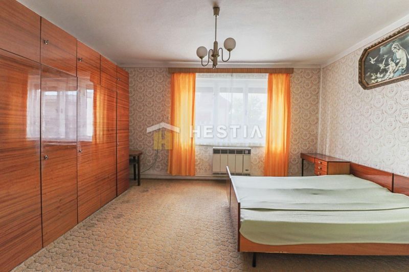 Das Interieur des Schlafzimmers mit Tapeten, Schränken und Bett in einem Einfamilienhaus.
