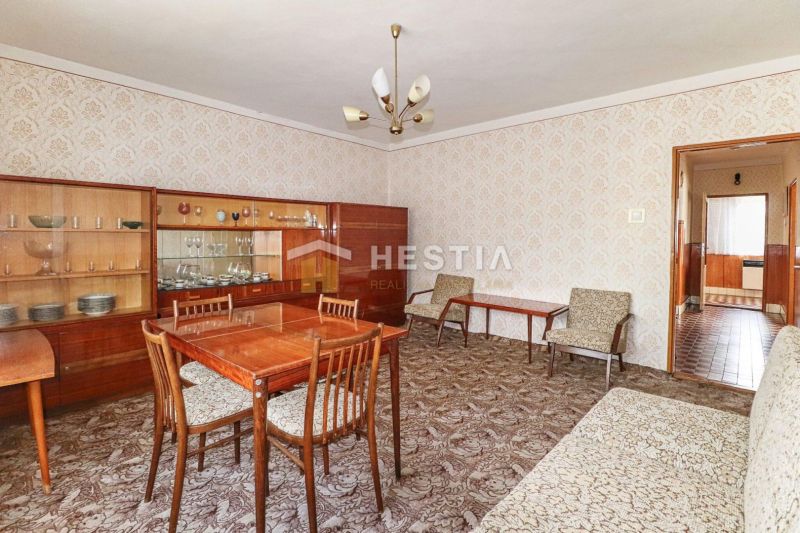 Innenraum eines Einfamilienhauses mit Möbeln aus dem 20. Jahrhundert und gemustertem Teppich.