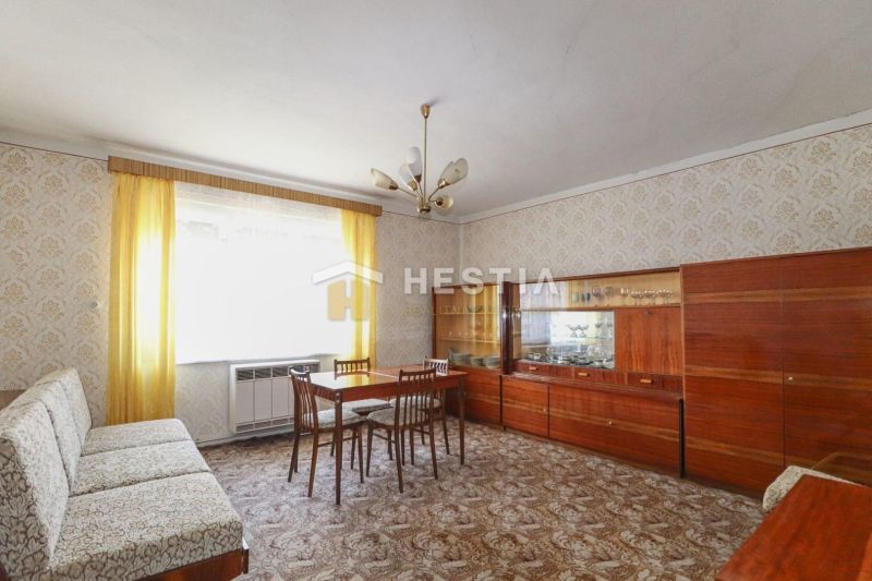 Wohnzimmer in einem Einfamilienhaus mit Holzmöbeln und gemustertem Teppich.