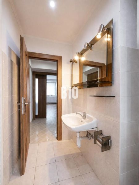 Badezimmer mit Waschbecken in einer 3-Zimmer-Wohnung mit Holzboden.