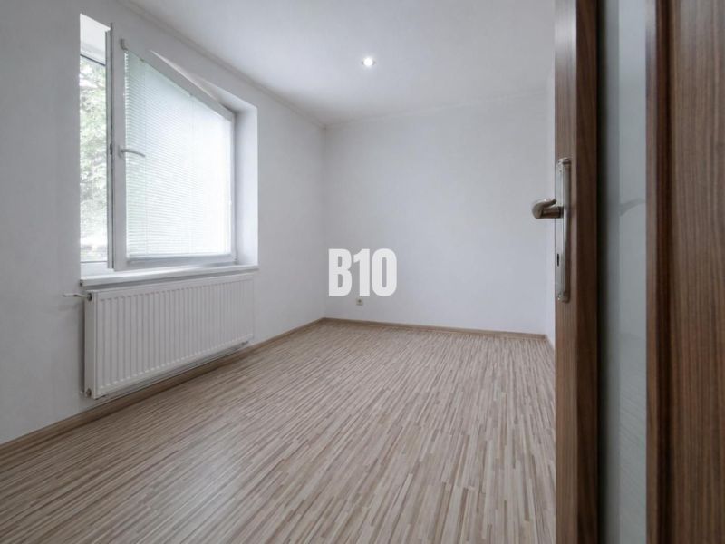 Ein leerer Raum mit Holzdekorboden in einer 3-Zimmer-Wohnung.