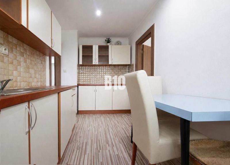 Küche in einer 3-Zimmer-Wohnung mit Holzboden und hellen Möbeln.