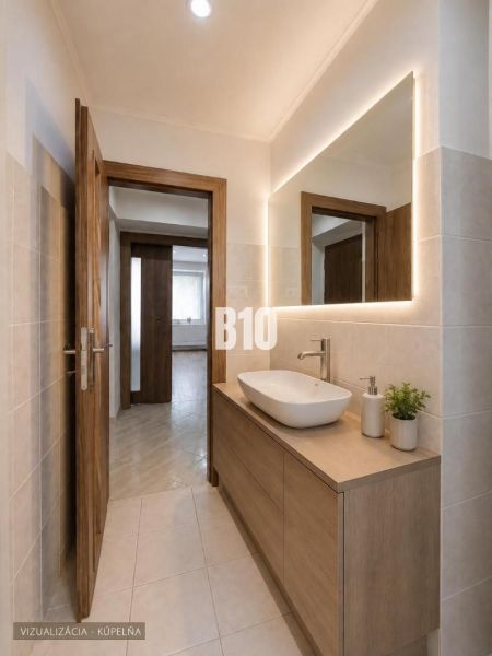 Badezimmer in einer 3-Zimmer-Wohnung mit Waschbecken und beleuchtetem Spiegel an der Wand.