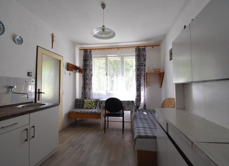 Einfache Küche mit Holzboden und Sofa in einem Einfamilienhaus.