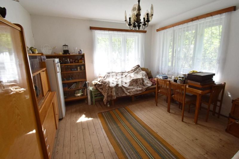 Wohnzimmer in einem Einfamilienhaus mit Holzboden, Sofa und Tisch.