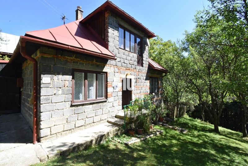 Ein Einfamilienhaus in Dlhé Pole, umgeben von Grün, mit einem Dachgeschoss und einem roten Dach.