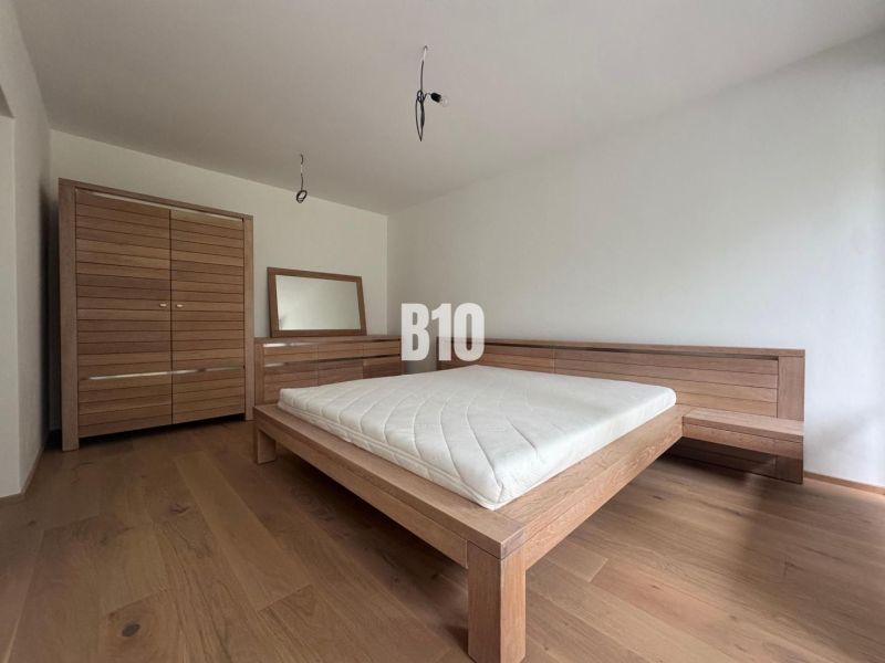 Schlafzimmer in einer 2-Zimmer-Wohnung mit Holzmöbeln und einem Boden mit Holzdekor.