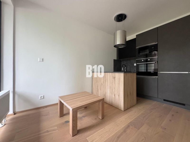 Küchenecke mit dunklen Schränken und Holzboden in einer 2-Zimmer-Wohnung.