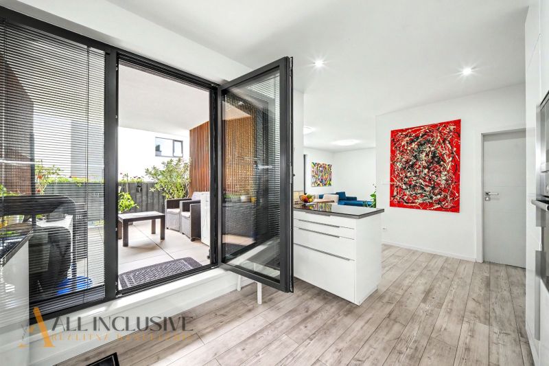 Innenraum einer 3-Zimmer-Wohnung mit Balkon, Holzboden und farbenfroher Kunst.