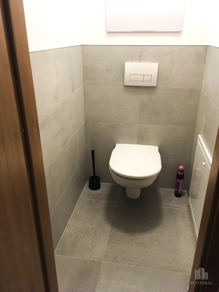 Badezimmer in einer 2-Zimmer-Wohnung mit Fliesen und einem hängenden WC.