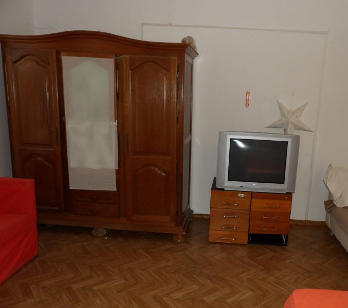Ein Zimmer in einer 2-Zimmer-Wohnung mit Holzmöbeln und einem Boden in Holzoptik.