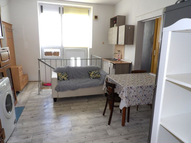Wohnzimmer in einer 2-Zimmer-Wohnung mit Holzboden und einfacher Einrichtung.