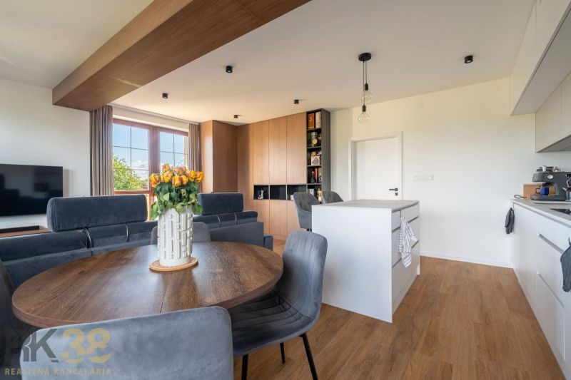 Wohnzimmer in einer Zweizimmerwohnung mit Holzboden und Esstisch.