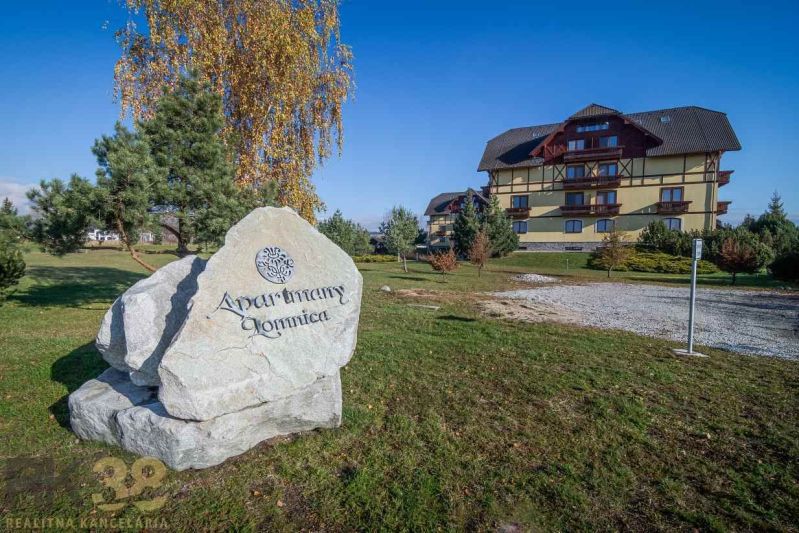 Wohnkomplex in Veľká Lomnica, auf einer Rasenfläche mit einem großen Steinschriftzug.