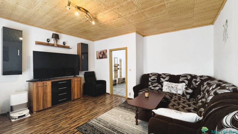 Wohnzimmer mit Sofa und Holzboden in einer 4-Zimmer-Wohnung.