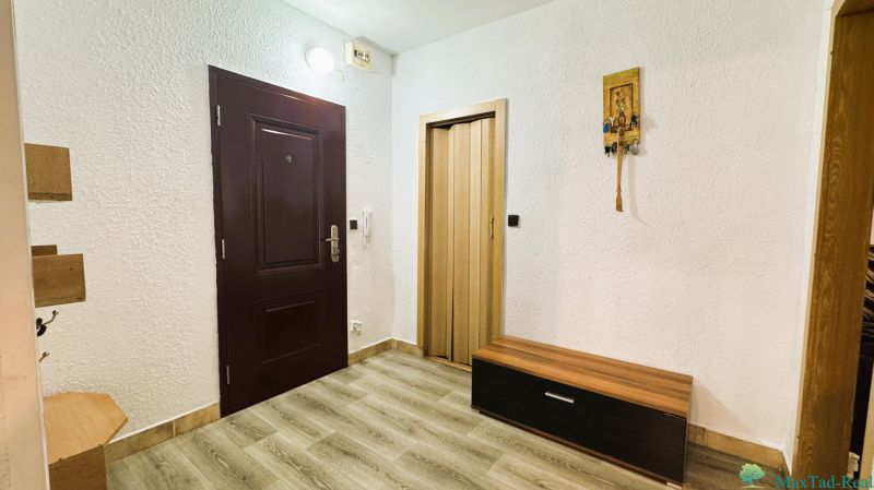 Innenraum einer 4-Zimmer-Wohnung mit weißen Wänden, Boden in Holzoptik und dunklen Türen.
