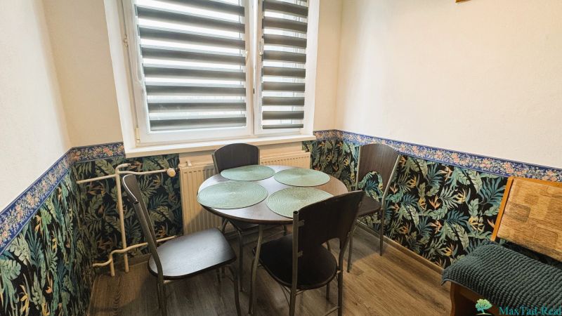 Essbereich in einer 4-Zimmer-Wohnung mit Blumen-Tapete und einem Tisch für vier Personen.