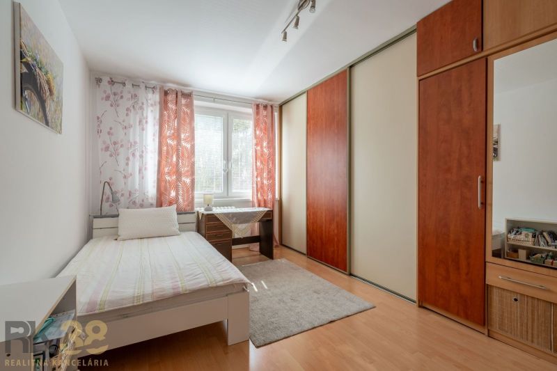 Helles Zimmer in einer 3-Zimmer-Wohnung mit großem Schrank und Schreibtisch.