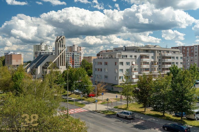 Blick auf die Ludvíka Svobodu Straße in Poprad mit einem sakralen Bauwerk und Wohnblöcken.