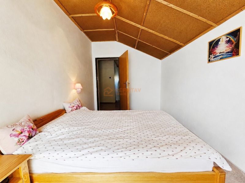 Schlafzimmer im Einfamilienhaus mit Doppelbett und Wandleuchten.