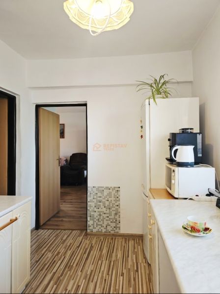 Küche in einem Einfamilienhaus mit Holzboden und Geräten.
