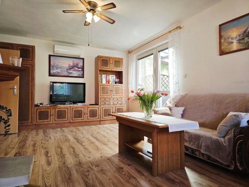 Wohnzimmer in einem Einfamilienhaus mit Holzboden und bequemen Sitzgelegenheiten.