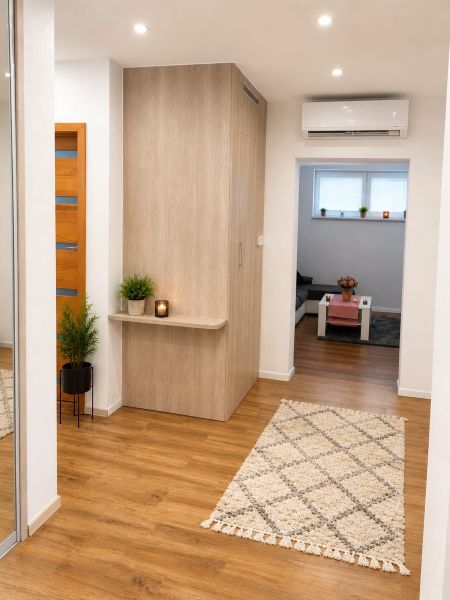 Innenraum eines Einfamilienhauses mit Holzboden, Teppich und Pflanzen dekorieren den Flur.