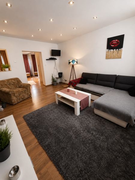 Wohnzimmer in einem Einfamilienhaus mit Holzboden und bequemen Sitzgelegenheiten.