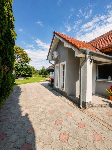 Ein Einfamilienhaus in Selice mit Terrassenfliesen, Garten und weißen französischen Fenstern.