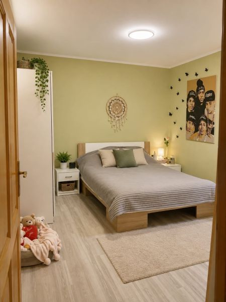 Schlafzimmer im Einfamilienhaus mit Bett, beigem Teppich und Wanddekoration.