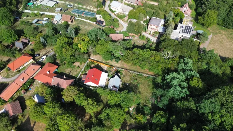 Luftaufnahme der Gärten in Kolačno mit verstreuten Häusern und üppigem Grün.
