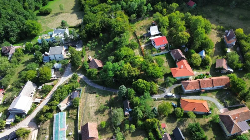 Ein Luftbild der malerischen Gärten in Kolačno mit verstreuten Häusern und Grünflächen.