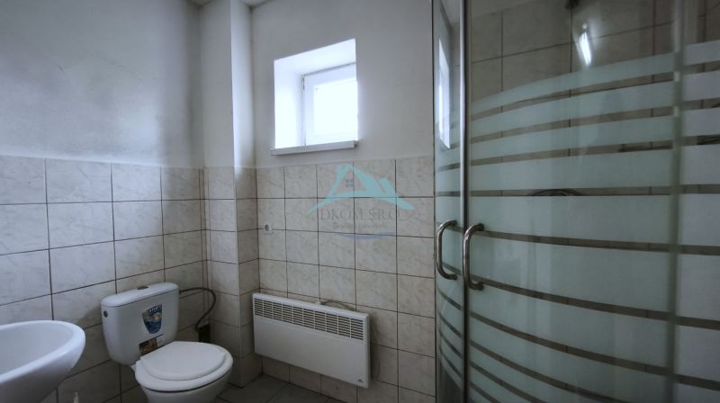 Badezimmer mit Toilette und Duschkabine in den Produktionsräumen.