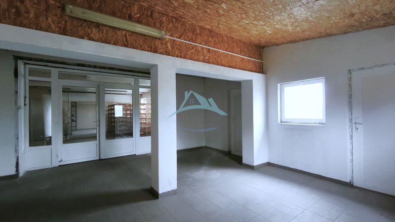 Produktionsräume mit weißen Wänden und einem Fenster, Boden mit Holzdekor.
