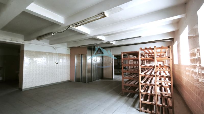 Produktionsräume mit Fliesenboden, Holzregalen und einem Aufzug.