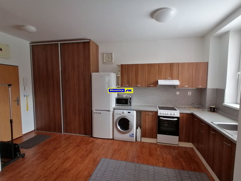 Küche in einer 2-Zimmer-Wohnung, Holzdekor auf dem Boden und der Küchenzeile.